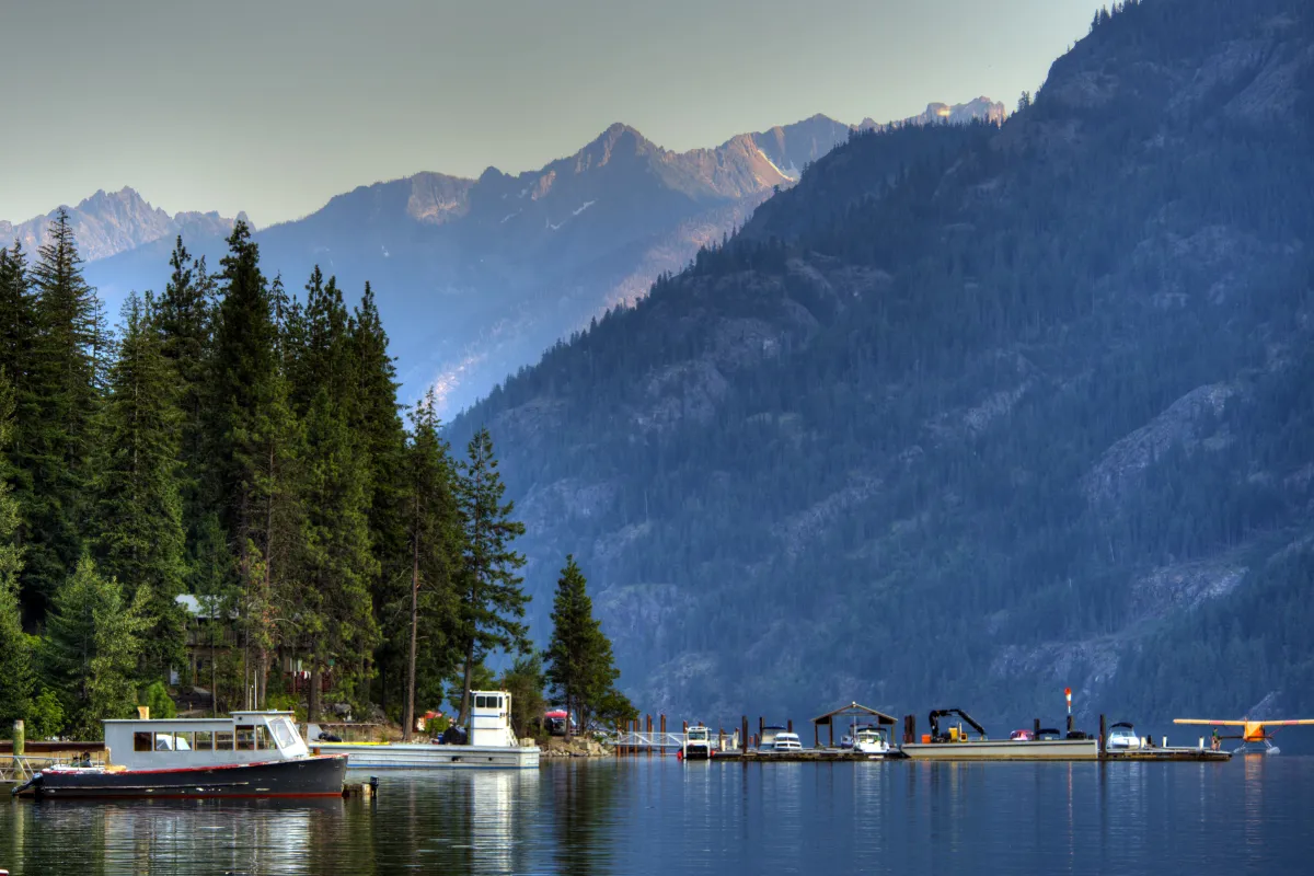 boats on the water with mountains and trees surrounding