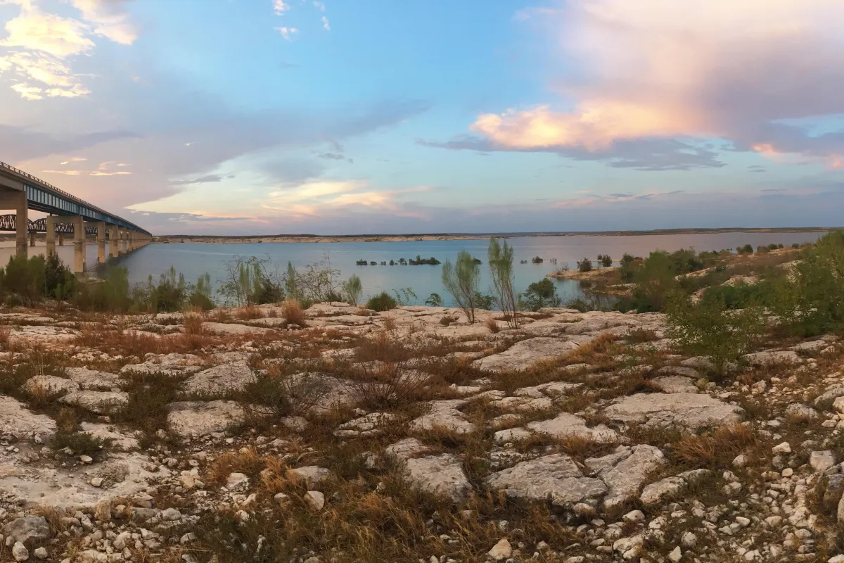 Sunset over Amistad Reservoir with Highway 90 bridge to left of photo going over the reservoir and i