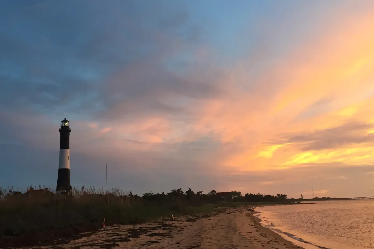 The Fire Island Lighthouse against a vibrant sunset.