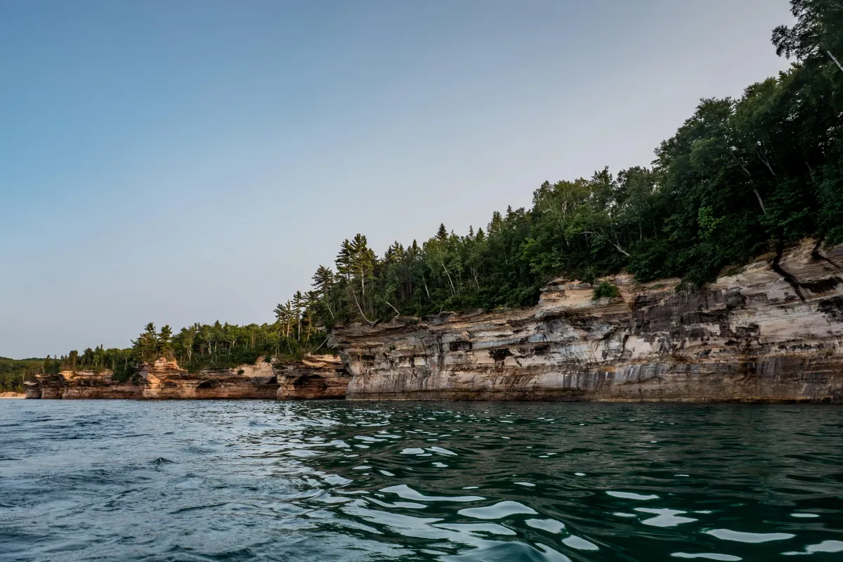 Multi-colored sandstone cliffs rise out of Lake Superior