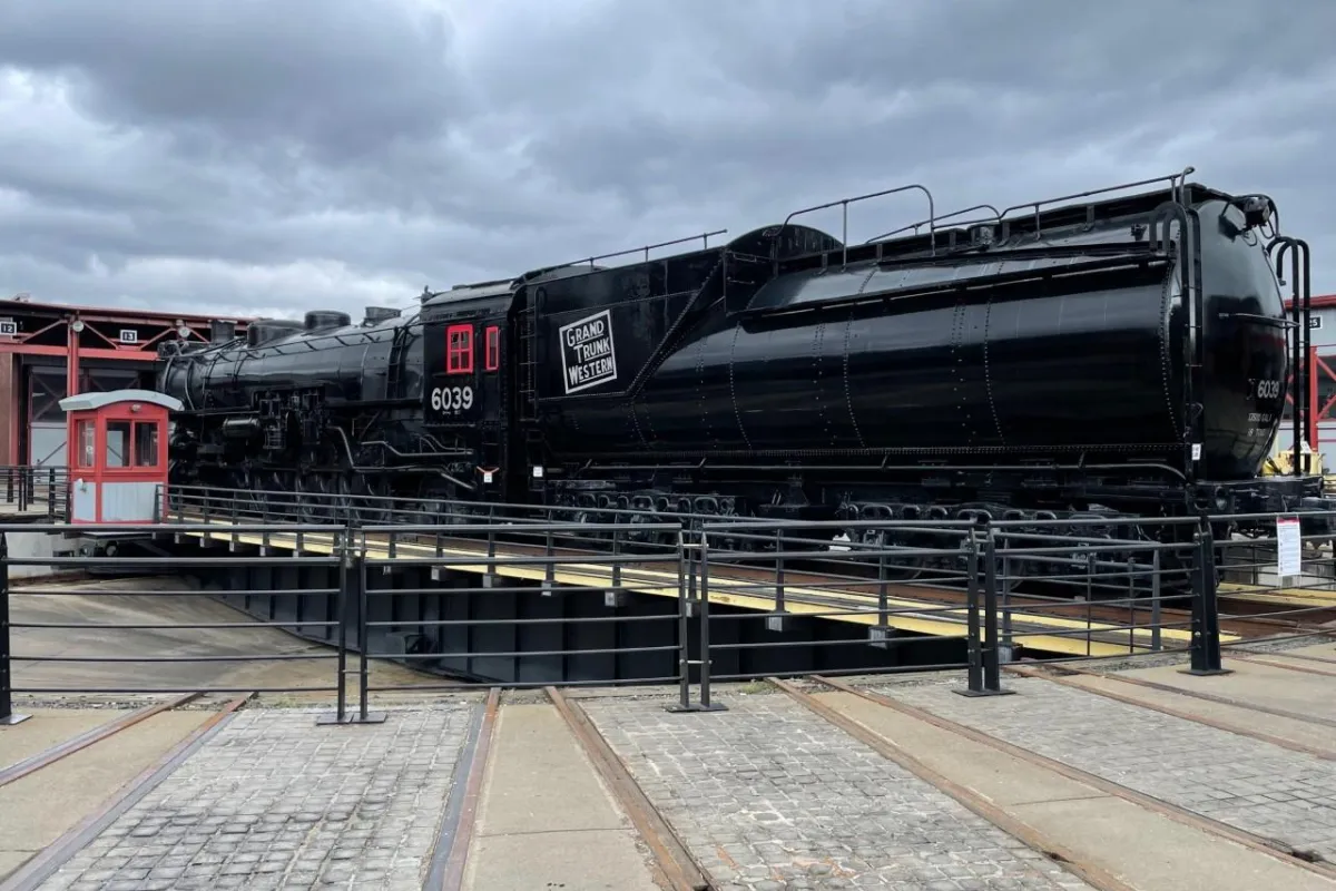 large black train with number 6039 painted in white lettering, sitting on turntable track