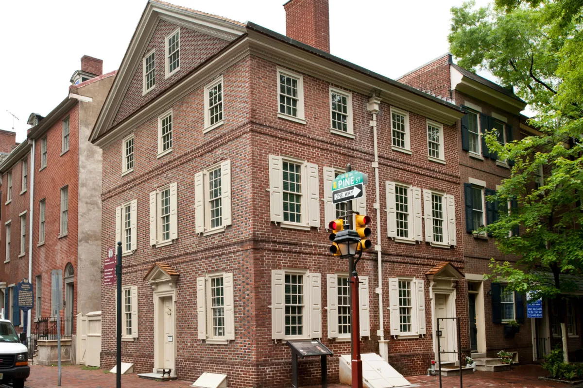 Color photo showing a three story brick rowhouse on a corner lot.