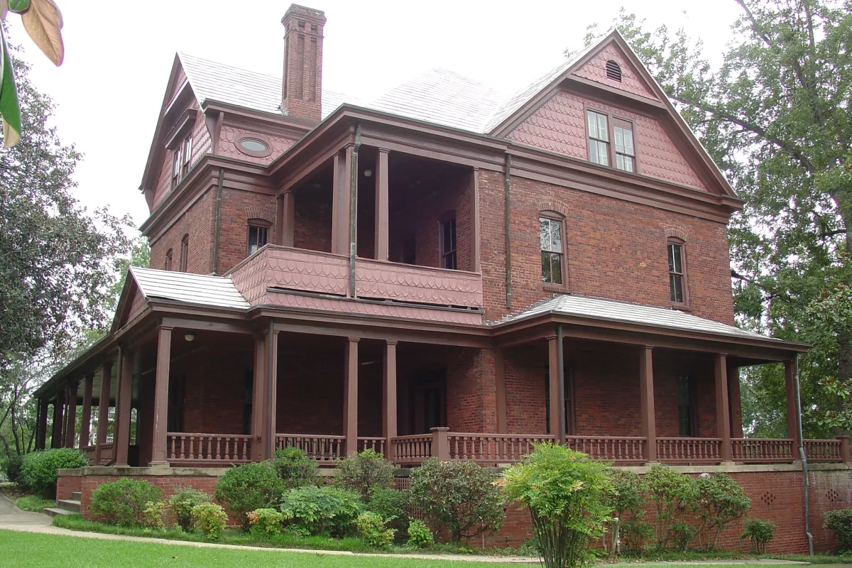 A three story Queen Anne Revival style red brick house